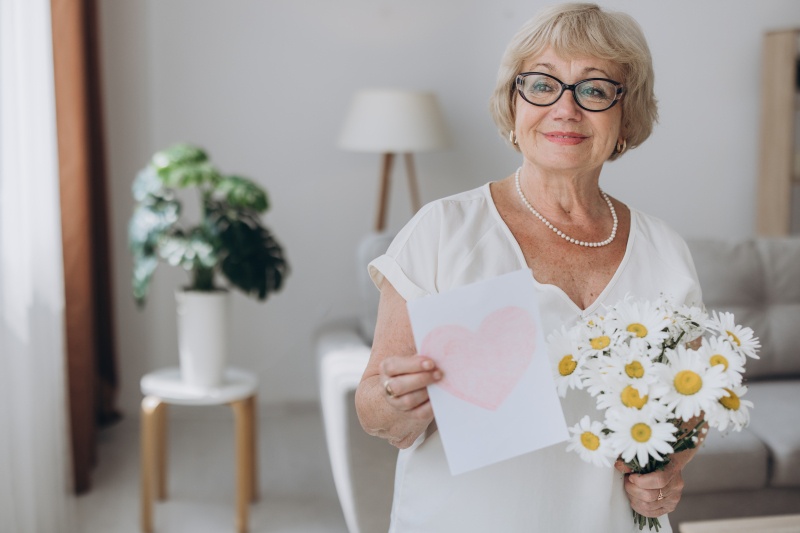 portrait-of-happy-senior-blonde-woman-holding-card.jpg